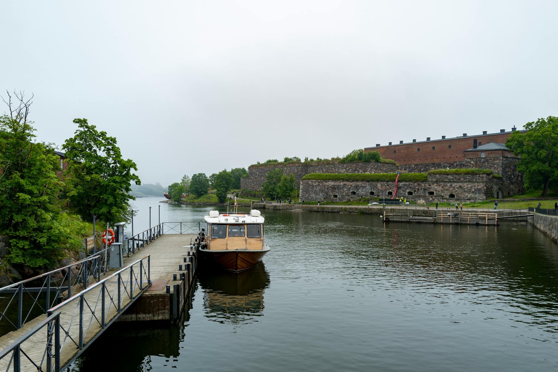 Łódź zacumowana w spokojnym porcie przy pochmurnej pogodzie