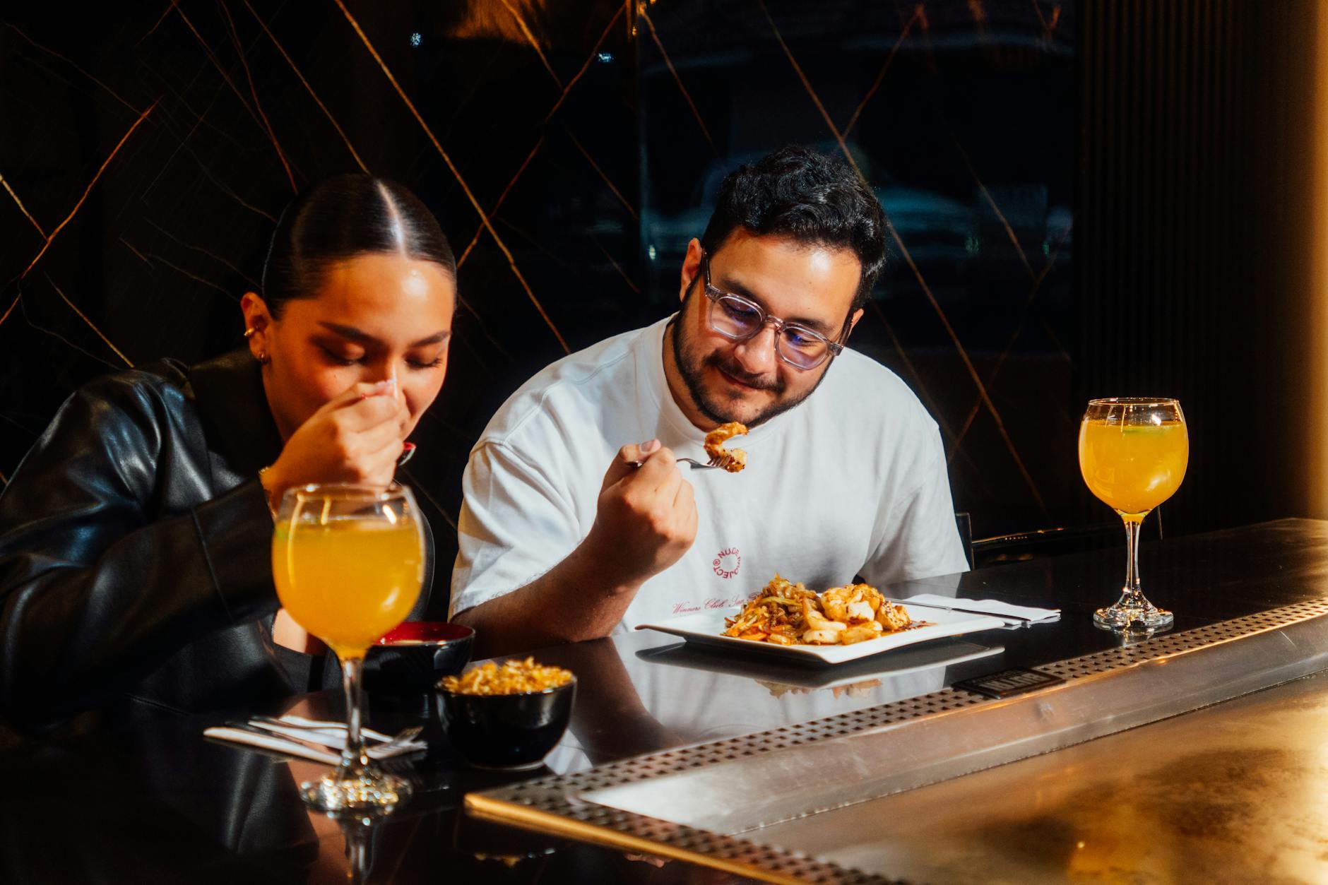 Para przy stoliku w restauracji, szef kuchni przygotowuje danie Para przy stoliku w restauracji, szef kuchni przygotowuje danie