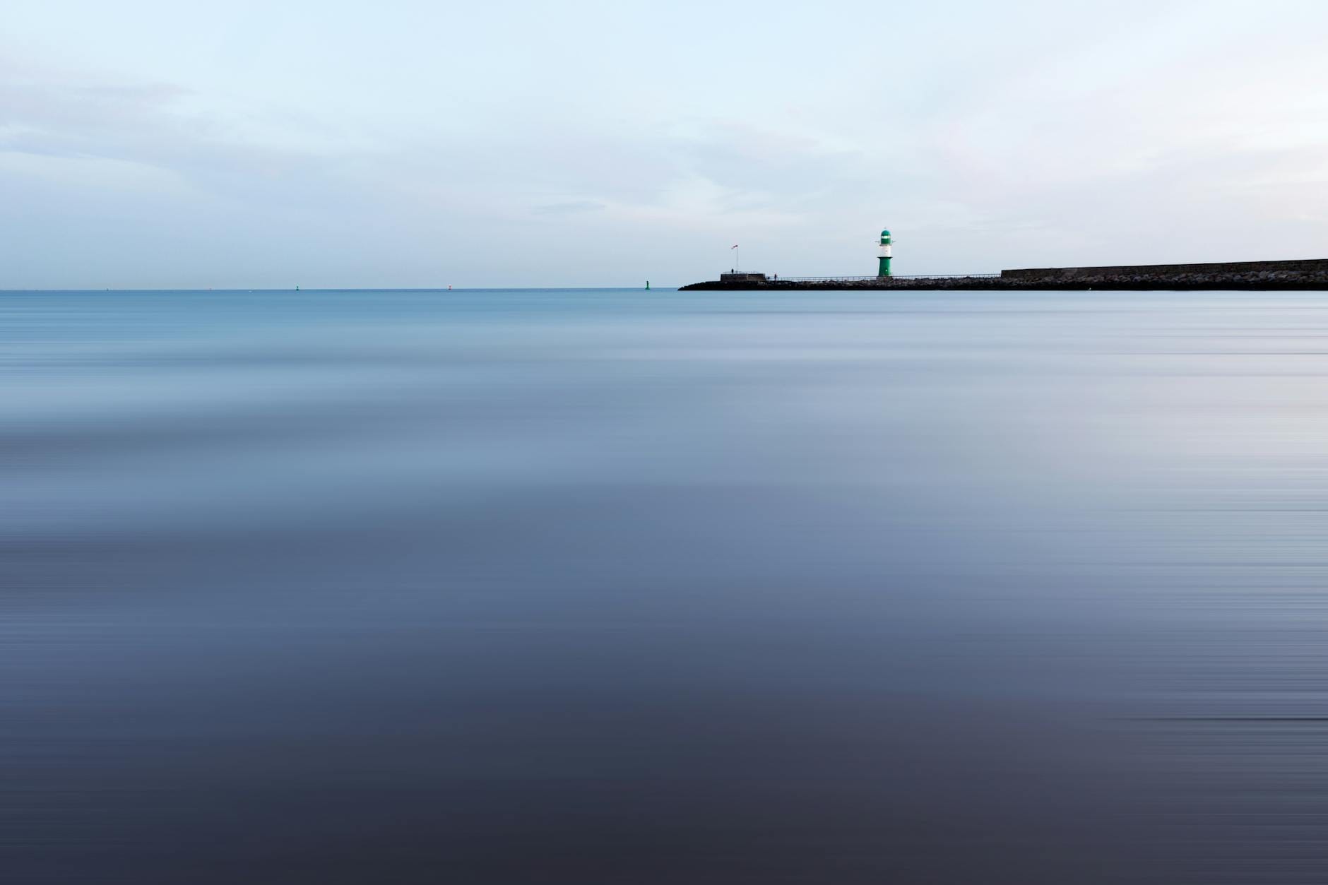 Spokojny widok na latarnię morską nad morzem przy bezchmurnym niebie
