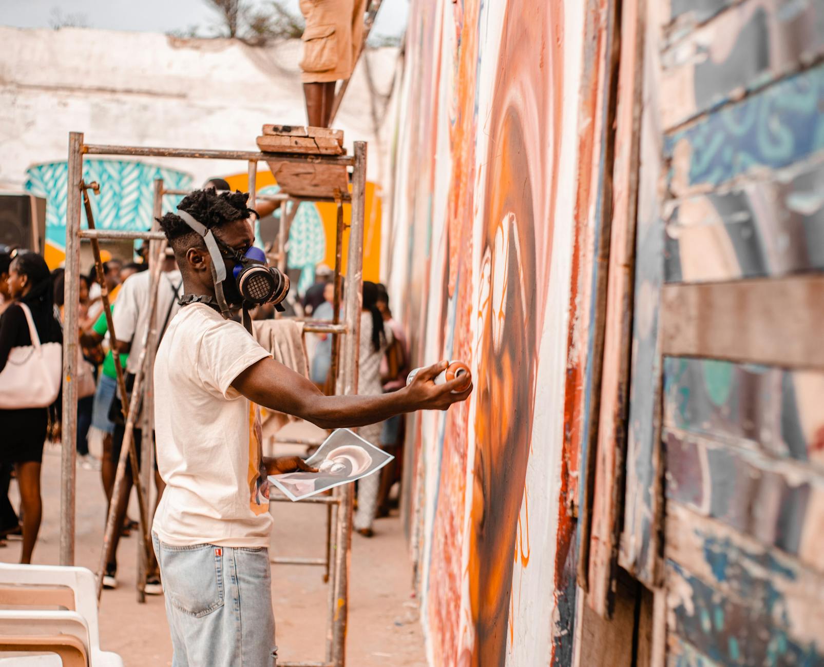 Artysta maluje kolorowy mural sprayem na zewnętrznej ścianie