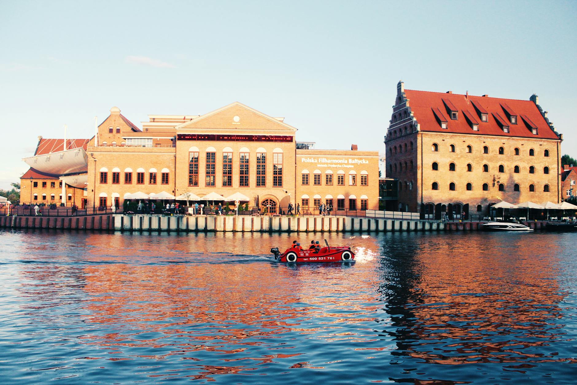 Gdańsk nad Motławą z historyczną zabudową i czerwoną łodzią