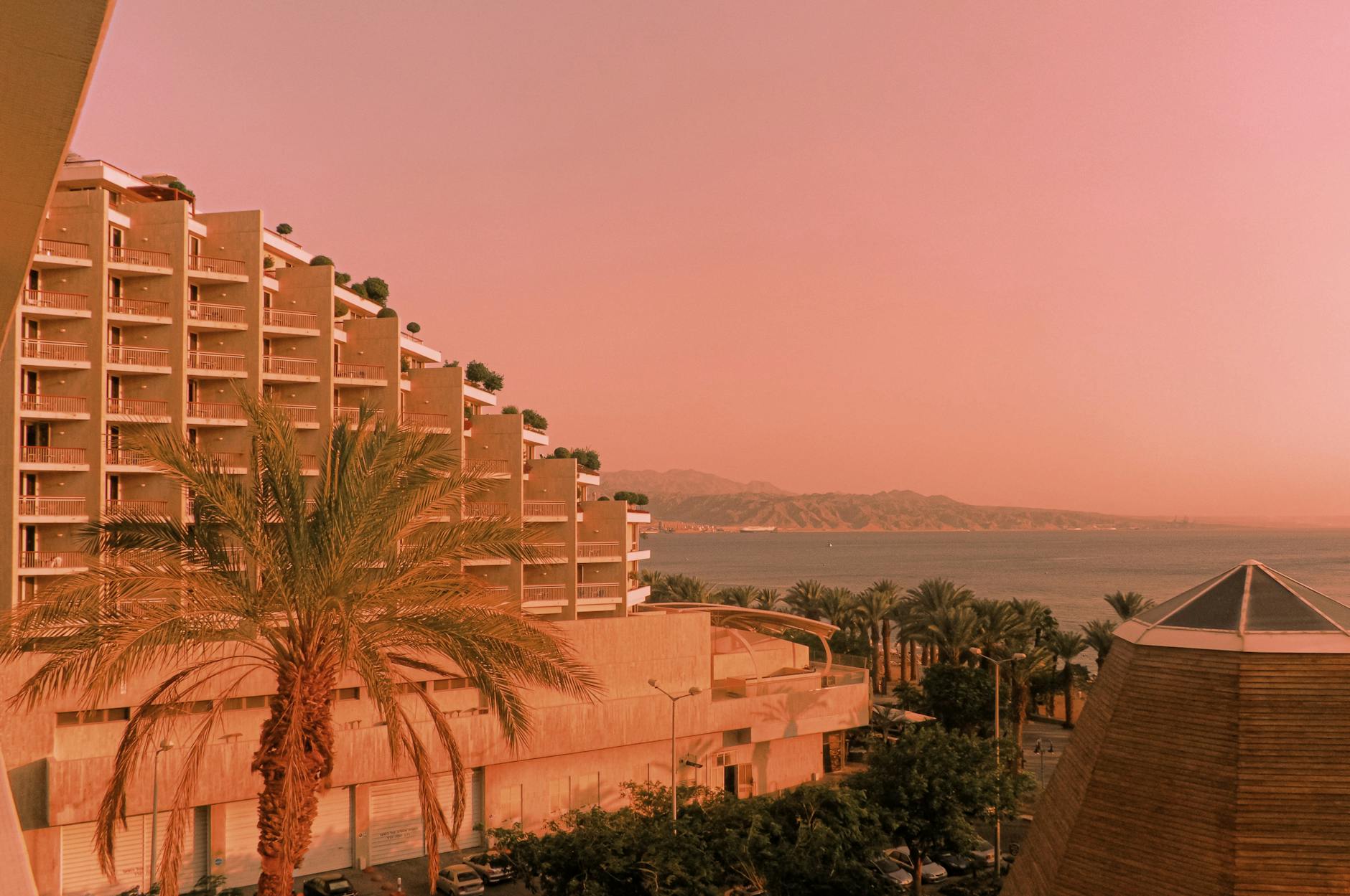 Nadmorski hotel o zachodzie słońca z palmami nad brzegiem morza