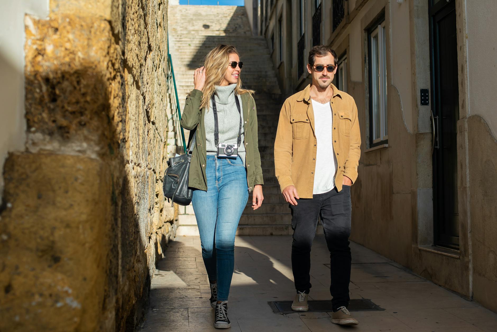 Para spaceruje wiosną w słońcu wąską uliczką w Trójmieście