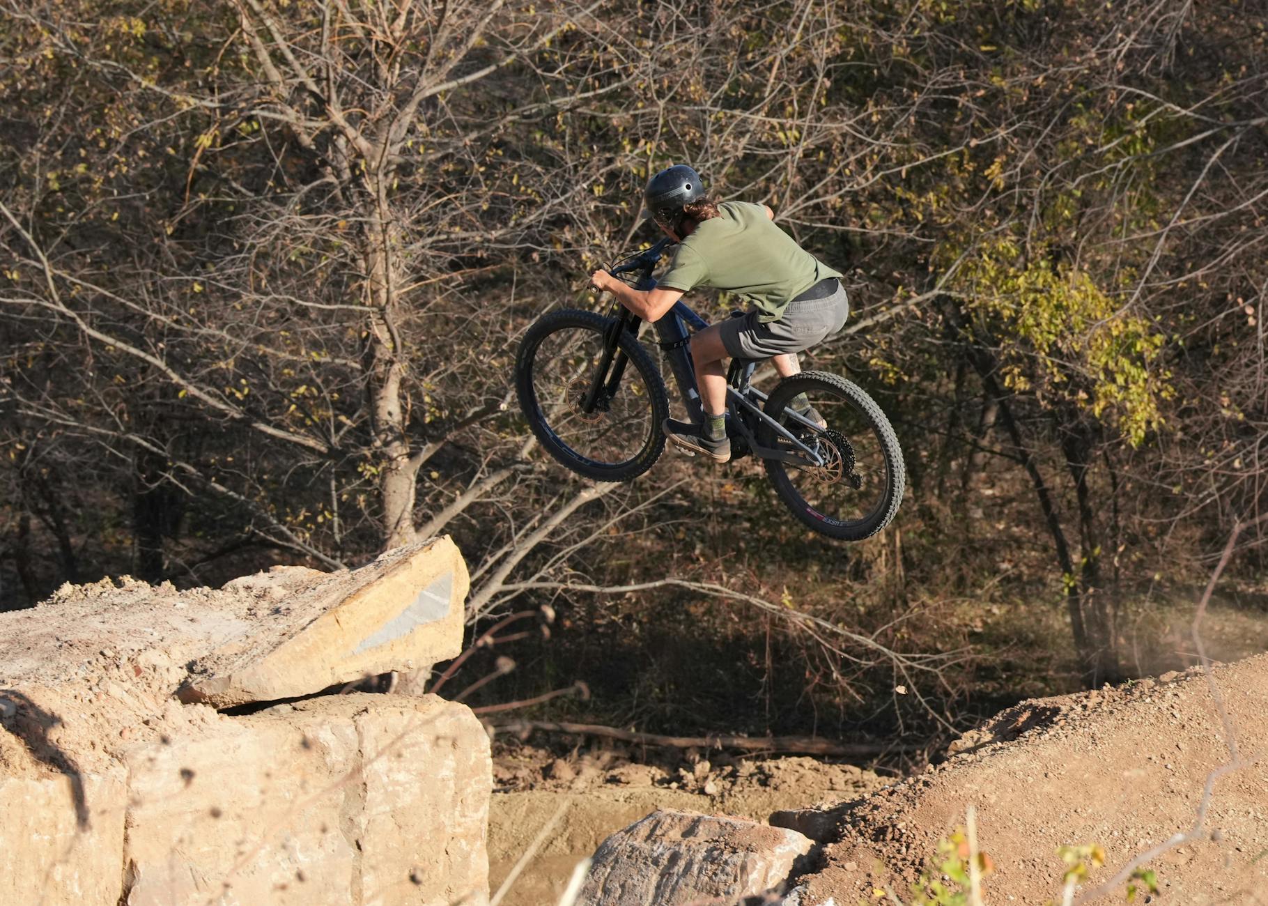 Rowerzysta BMX skacze na leśnym singletracku
