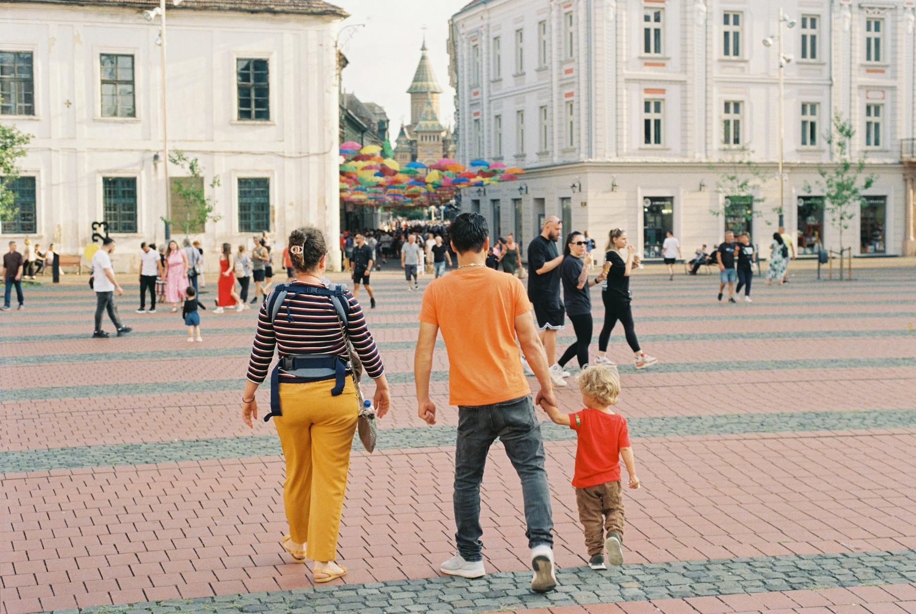 Rodzina spaceruje po kolorowym, tętniącym życiem miejskim placu